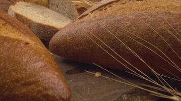 Kamera ist Zoomen durch geschnitten und ganze Weizen Brot und Weizen Ohren zu das Lehm Töpfe video