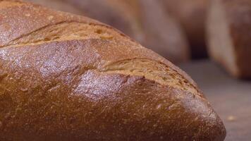 Kamera ist Zoomen durch geschnitten und ganze Weizen Brot und Weizen Ohren zu das Lehm Töpfe video