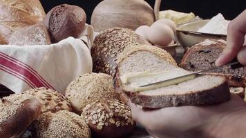 handen boter een stuk van vers gebakken brood bovenstaand de tafel video