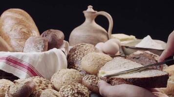 Hands butter a piece of fresh baked bread above the table video