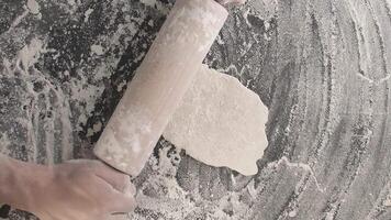 Male hands roll out baking dough using rolling pin on a wooden board video