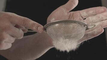 Close-up of male hands sifting flour through small metal sieve video