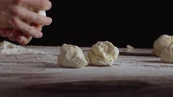 Male hands divide baking dough into shares on a board sprinkled with flour video