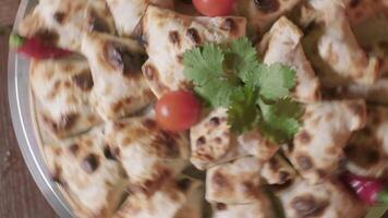 avvicinamento di rotante piatto con Samsa centrale asiatico panini decorato con prezzemolo video