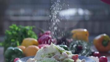 Close-up of coarsely chopped Caesar salad with chicken fillet in the ceramic dish is is sprinkled video