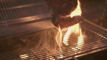 Close-up of big stake grilled on the big open fire and turned with tongs video