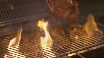 Close-up of big stake grilled on the big open fire and turned with tongs video