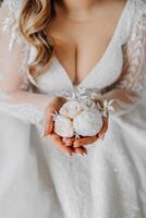 wedding boutonniere in the hands of the bride. The first meeting of the bride and groom. The bride puts on a bootie over the groom's jacket photo