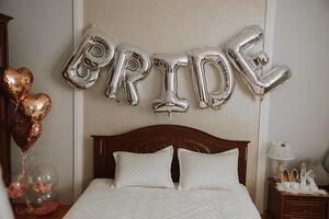 The inscription of the bride of silver balls above the bed on the wedding day. The room is prepared for the morning of the bride. photo