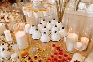 Candy bar for a wedding. Candy bar standing festive table with desserts, cupcakes and macarons. Beautiful and tasty. photo