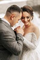 The groom holds the bride's hands. Sincere emotions. A walk in the forest. Winter wedding photo