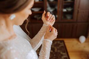 el novia sujeta el manga de su Boda vestido. Mañana de el novia. preparación. Boda fotografía foto