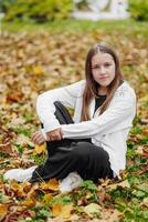 Vertical photo. Beautiful carefree young teenage girl in casual clothes. Portrait of a beautiful girl against the background of nature with a blurred background. photo