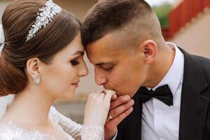 She told him yes. A young man kisses his wife's hand with a gold ring, proposing marriage. Engagement of a young couple in love. Concept of love and unity. photo