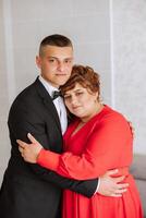 mother helps her adult son prepare for the wedding ceremony. An emotional and touching moment at a wedding. A mother hugs her son photo