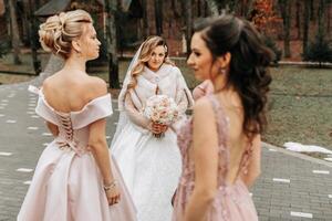 novia con damas de honor en el parque en el Boda día foto