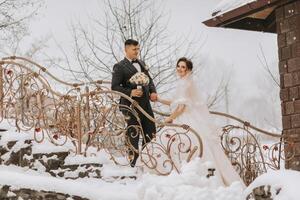Horizontal shot of a beautiful bride and groom walking and enjoying the park on a snowy winter day. Winter wedding. photo