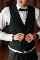 recortado foto de novio en blanco camisa abotonarse negro chaleco. negocio estilo. un elegante reloj