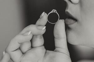 de cerca de un elegante diamante anillo en un mujer dedo con un moderno manicura, luz de sol. amor y Boda concepto. suave y selectivo enfocar. foto