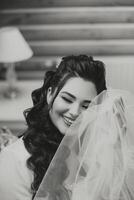 A beautiful brunette bride with a tiara in her hair is getting ready for the wedding in a beautiful robe in boudoir style. Close-up wedding portrait, photo. photo