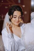 un contento novia es preparando para su lujoso Boda en un hotel habitación, con un Boda vestir en un maniquí cercano. retrato de un mujer con de moda cabello, maquillaje y un sonrisa en un vendaje vestido. foto