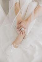 The bride puts on her wedding shoes. Elegant bridal shoes. Close-up photo. Preparation for the wedding ceremony photo