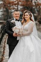 Wedding couple in love. A beautiful bride and an elegant groom tenderly embrace and enjoy the day. A stylish couple of newlyweds. Concept of marriage photo