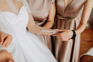 el damas de honor ayuda el novia obtener vestido. preparación para el boda. Mañana de el novia foto