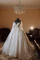 wedding dress in the interior of the bride's room. Voluminous wedding dress with sleeves and open shoulders. photo