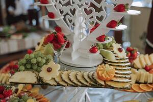 A banquet table full of fruits and berries, an assortment of sweets. Bananas, grapes, pineapples. Fruit compositions for the holiday. photo