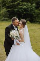 Wedding. Love and couple in garden for wedding. Celebration of ceremony and commitment. Save the date. Trust The groom embraces the bride in the mountains on the background of the forest photo