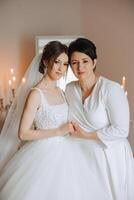 A beautiful and happy mother and her daughter, the bride, are standing next to each other. The best day for parents. Tender moments at the wedding. photo