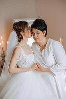 A beautiful and happy mother and her daughter, the bride, are standing next to each other. The best day for parents. Tender moments at the wedding. photo