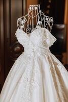 Bedroom interior with wedding dress prepared for the ceremony. A beautiful lush wedding dress on a mannequin in a hotel room. photo