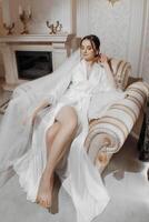 A luxurious bride in a wedding dress in the morning in her interior. photo