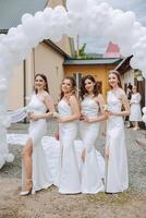 Friends rejoice with the bride in the morning. They take pictures, smile, help the bride fasten her dress. photo