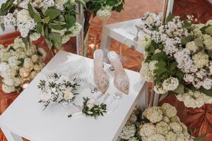 Details of the bride. Beauty is in the details. High-heeled bridal shoes. Gold wedding ring with a diamond. Perfumes. Earrings Wedding in details. photo