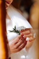 wedding boutonniere of flowers in the hands of the bride. Wedding details. The first meeting of the bride and groom. The bride is waiting for the groom. photo