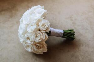 A bouquet of white roses on a cream background. Morning of the bride photo
