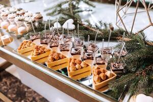 un delicioso boda. blanco pastel decorado con flores caramelo bar para un banquete. celebracion concepto. de moda postres mesa con dulces, dulces. frutas foto