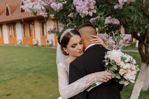 boda. amor y Pareja en jardín para boda. celebrando el ceremonia y compromiso. salvar el fecha. confianza. el novia y novio abrazo en contra el antecedentes de un primavera floreciente árbol. foto