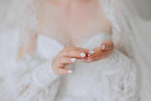 Close-up of an elegant diamond ring on a woman's finger with a modern manicure, sunlight. Love and wedding concept. Soft and selective focus. photo