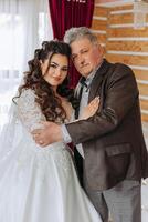 A beautiful bride with her father on her wedding day. The best moments of the wedding day. Daughter and father. photo