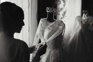 Bedroom interior with wedding dress prepared for the ceremony. A beautiful lush wedding dress on a mannequin in a hotel room. photo