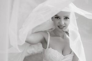 young beautiful bride on her wedding day under a veil on a summer day photo