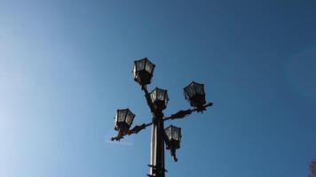 klassisch älter Lampe und Blau Himmel. alt gestaltet Straße Licht gegen ein Blau Himmel. Jahrgang Stil Straße Beleuchtung durch das Tag. Aufnahmen video
