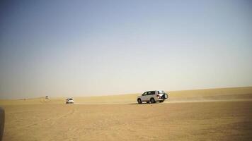 antenne visie Aan van de weg af avontuur met suv in Arabisch woestijn Bij zonsondergang met Dubai horizon of stadsgezicht. woestijn toeren met suv. van de weg af suv rijden in de woestijn. het rijden een 4-wiel rit suv Aan de video