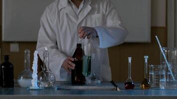 água purificação teste. solta azul líquido dentro teste tubo com limpar \ limpo água. cientista fazendo químico experimentar video