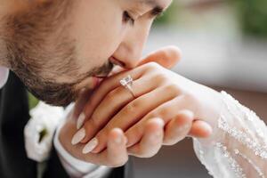 Gentle touch of the groom to the bride, walk of the bride and groom. Beautiful bride. Newly created wedding family. The groom kisses the bride's hand. Beautiful young couple in love photo