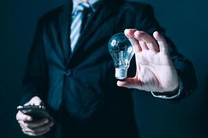 person hand holding power lightbulb and pretend to think, inspiration, creativity and imagination concept, innovation technology success business. Digital transformation. photo